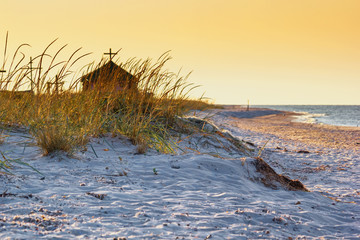 Seaside landscape - sunrise on the seashore with Orthodox Skete against the background of an summer sky