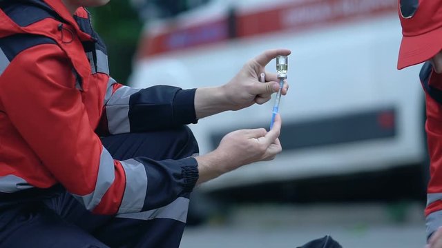 Ambulance doctor making injection to girl who lost consciousness, asthma attack