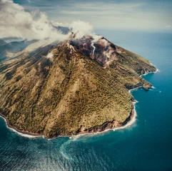 Tuinposter Fog over Indonesia volcano. Aerial drone shot. Amazing overview of Indonesian land surrounded by the ocean. Asian landscape. Active volcano among the calm blue ocean water. Cloudy sky background. © Goinyk