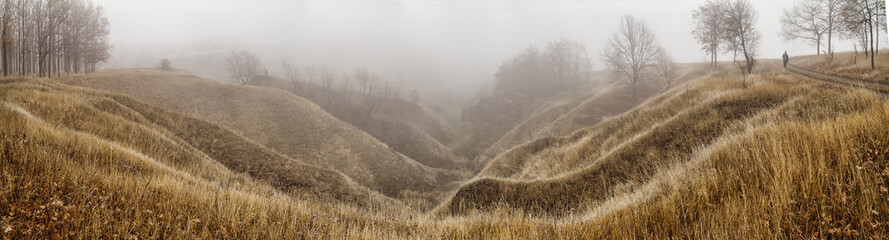 Autumn landscape, panorama - spurs of ravine near winding river, covered with fog, over the meadows between hills and forests, the northeast of Ukraine
