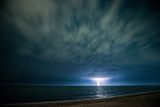 Night thunderstorm with lightning above the sea