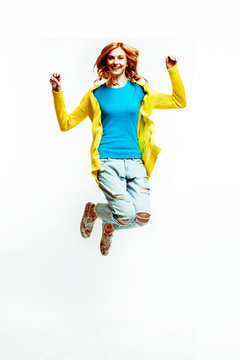 pretty young redhad teenage girl  jumping happy smiling on white