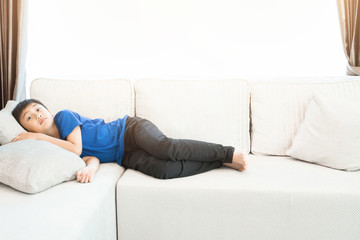 A little boy lying in living room at home