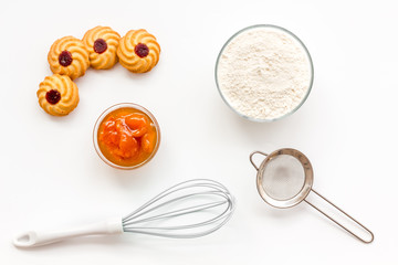 Cook cookies at home concept. Fresh cookies near whisk, flour, sieve on white background top view