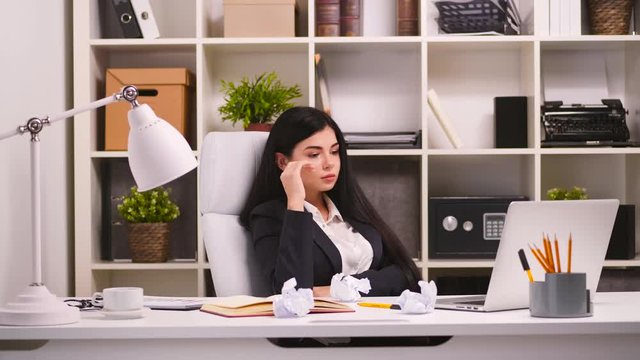 Pretty businesswoman in her office. Crumple up a piece of paper. Job is undone. 4k