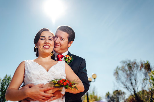 ust married couple embracing themshleves in the countryside