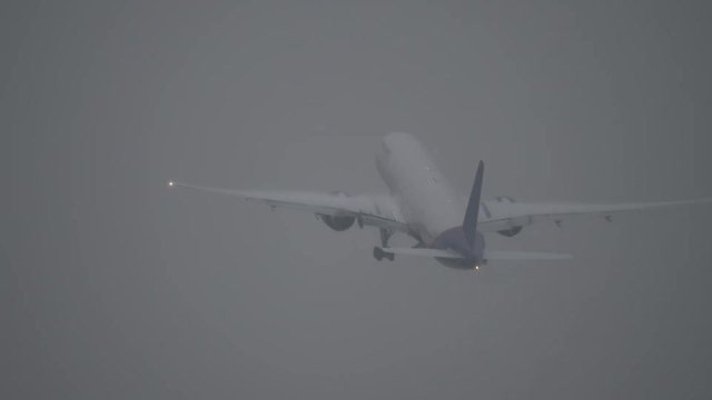 Long shot of a jet plane taking off during a storm on a wet runway