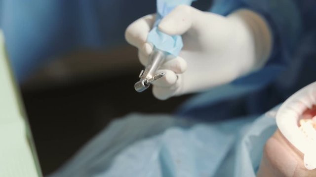 Close up image of dentist's hand, holding dental instrument