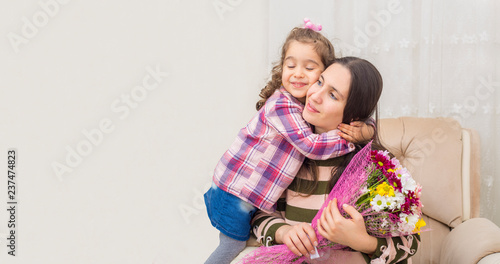 mother and daughter hugging each other. daughter giving Flowers to Mother Mother's Day