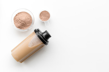 sport nutrition set with protein powder for cocktail and scoop on white background top view space for text