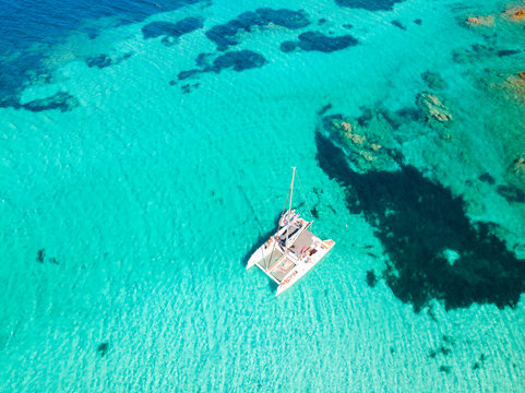 Fototapeta Drone aerial view of catamaran sailing boat in Maddalena Archipelago, Sardinia, Italy. Maddalena Archipelago is a group of islands between Corsica and north-eastern Sardinia.