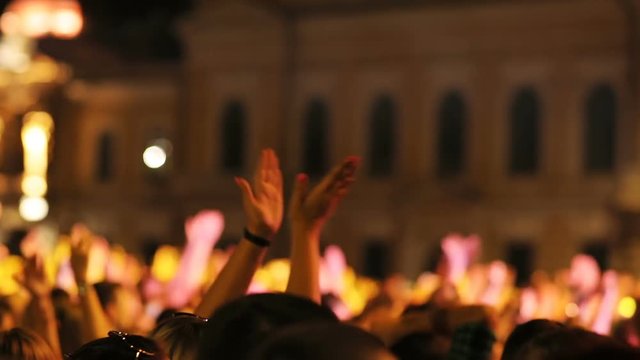 Berlin, Germany - 14 August 2018: Cheering crowd enjoying musical concert. Young people applauding, holding smartphones in hands. Amazing architecture. City, evening, outdoors.