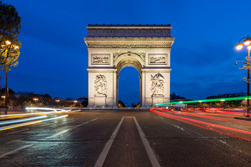 Fototapeta premium Paris street at night with the Arc de Triomphe in Paris, France.