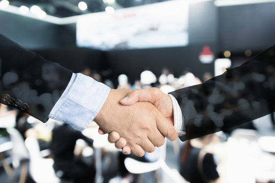 Deal or agreement business concept, handshake double exposure, coperation or partnership business with seminar conference meeting in background.