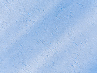 Aerial view on the texture of snow with shadow from trees on the surface of a winter lake 