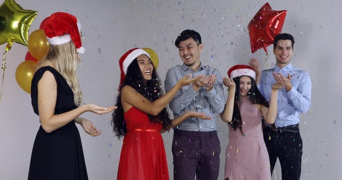 Group of Asian and Caucasian people in New year party, confetti spreading, concept for New Year party.