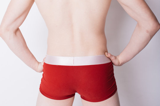 Foto Stock sexy guy with red boxer briefs. a man with a crown on his head.  body parts: back and elastic ass in underwear. men's health: hemorrhoids  and curvature of the spine
