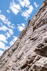 Fototapeta premium The last movements to reach the summit by a male climber. Rock climbing inside Andes mountains and valleys at Cajon del Maipo, an amazing place to enjoy rock climbing and mountaineering sports, Chile 