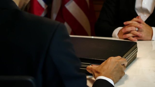 Business man giving bribe money in a briefcase while give success the deal to finishing contract agreement, Bribery and corruption concept.