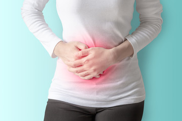 Woman stomachache on wall background.