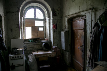 Dark and shabby messy kitchen in poor  apartment of old emergency house