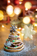 Christmas tree made out of dried orange slices and anise star, with festive light on background, vertical composition