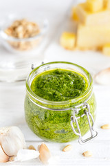Home made Basil pesto sauce and fresh ingredient on white background, vertical composition