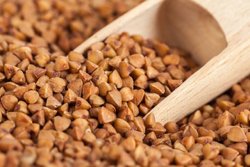 Group of buckwheat groats in a wooden spoon, healthy food