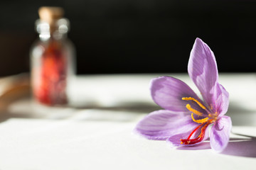 Obraz na płótnie Canvas Saffron flower and dried saffron spice in a bottle