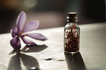Saffron flower and dried saffron spice in a bottle