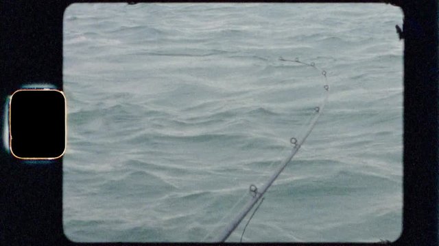 Super 8 film footage of fishing rod bending while on a boat in Alaska