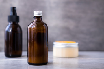 Spa cosmetics in bottles on gray concrete table. Copy space for text. Beauty blogging, salon therapy, branding mockup, minimalism concept