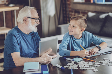 Pleased mature male person communicating with grandson