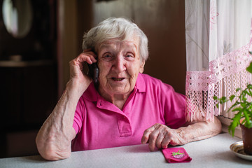 Elderly senior woman talks on a mobile phone.