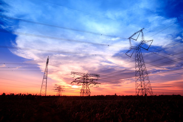 Obraz premium In the evening, the silhouette of high voltage towers