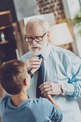 Attentive bearded mature man preparing for date