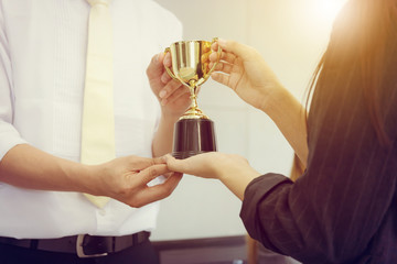Business man and woman holding trophy success celebration team concept.