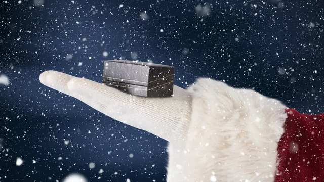 Santa clause holding a present in his hand combined with falling snow