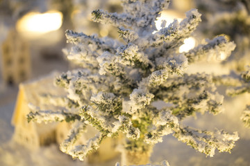 Snowy village of White Christmas and wooden house. miniature Christmas tree in the snow and decorations.