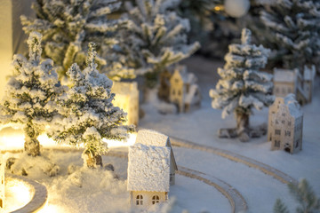Snowy village of White Christmas and wooden house. miniature Christmas tree in the snow and decorations.