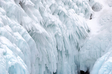 Ice splashes of waves on shores of Baikal, Ice blocks and icicles on coast rocks.