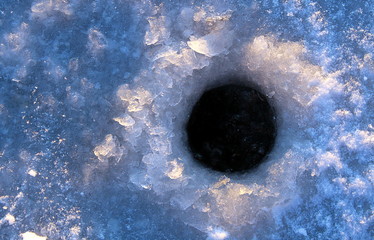 on the ice drilled a hole for fishing