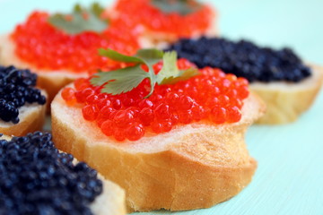 Red and black caviar of fish lies on wheat bread