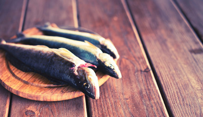 Banner catch of fresh sea fish lies on a cutting Board on a wooden table in the kitchen Selective...