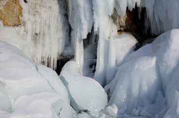 Ice blockes and walls on frozen rocks and stones, formed during freezing of lake Baikal