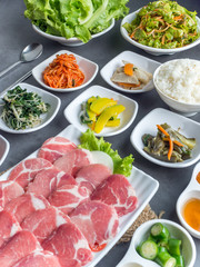 Set of slice raw pork ready to grill korean style, include slide food with vegetable and rice.