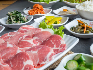 Set of slice raw pork ready to grill korean style, include slide food with vegetable and rice.