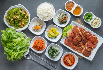 Set of slice raw pork ready to grill korean style, include slide food with vegetable and rice.
