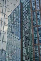 Abstract patterns formed by the reflections of buildings  in the glass facade of a modern office building.