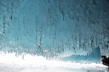 Frozen Baikal water. Transparent blue icicle ceiling